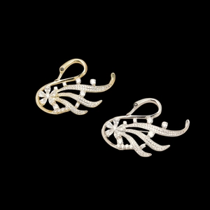 Elegant gold and silver swan brooches set with sparkling cubic zirconia on black background