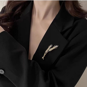 Macro shot of elegant golden wheat brooch with micro-pave zircons on a black suit blazer