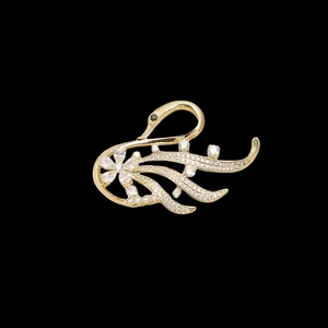 Macro shot of gold-plated swan brooch featuring sparkling white zircons and black eyes