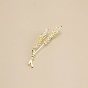 Classic golden wheat stalk brooch with micro-paved yellow zircons on beige background
