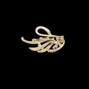 Macro view showing the sturdy safety pin closure and hollow metal back of the swan brooch