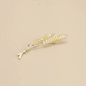 Detail of elegant gold wheat brooch with sparkling cubic zirconia stones and wheat ear design