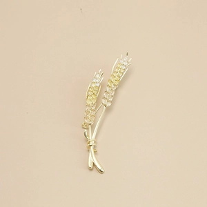 Macro shot of gold wheat brooch with sparkling yellow cubic zirconia stones detail