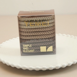 Set of 8 elastic hair ties in gradient earthy tones inside a transparent plastic gift box