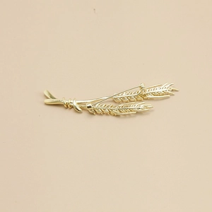 Detail of classic golden wheat brooch showing cubic zirconia stones and grain texture