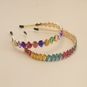 Detailed top view of two thin gold metal headbands with colorful rhinestone crystals
