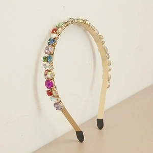 Détail d'un serre-tête en métal doré orné de strass et cristaux multicolores facettés