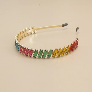 Detail of colorful rhinestones on a golden metal headband with rainbow crystals