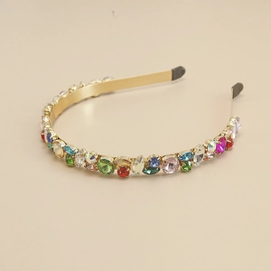Détail d'un serre-tête doré orné de strass colorés avec embouts de protection en caoutchouc