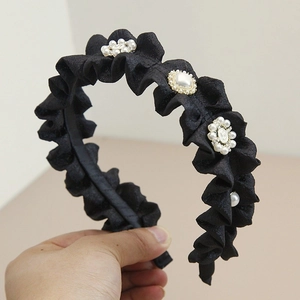 Detail of vintage black pleated headband with small pearls and number 5 decorative charms
