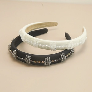 Détail de perles en cristal fait main sur un serre-tête élégant en satin noir et crème