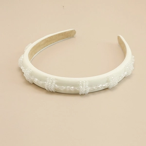 Détail du serre-tête crème avec cristaux brillants et texture satinée élégante