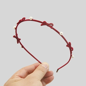 Detail of red velvet headband with bows and white pearls for a vintage look