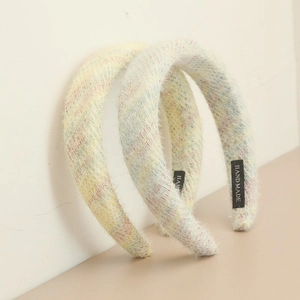 Détail d'un serre-tête large en éponge duveteuse avec texture peluche et étiquette faite main