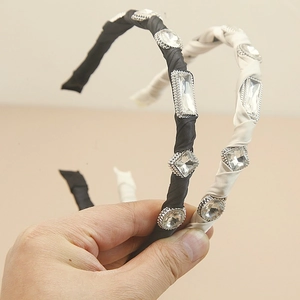 Detail of handmade baroque crystal headbands featuring black and white satin fabric wrapping