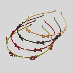 Detailed view of flocked headbands set featuring delicate bows and pearl embellishments