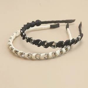 Dettaglio di fibbie a cuore con strass su cerchietti in seta nei colori nero e beige