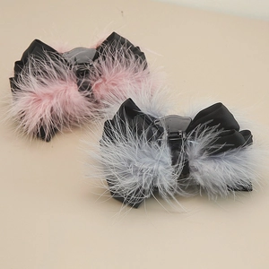 Detail shot of the fluffy ostrich feather bow hair claws in pink and grey finishes