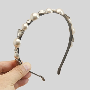 Detail of elegant headband with pearls and rhinestones on slim black metal frame