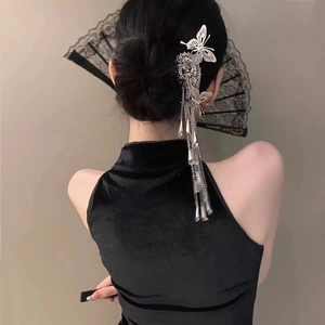 Detailed view of a silver butterfly hair stick with long tassels worn in a bun hairstyle