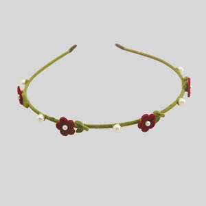Detail of flocking floral headband with red flowers and white pearls on green band