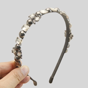 Detail of vintage crystal hairband with dark pearls and butterfly ornament decorations