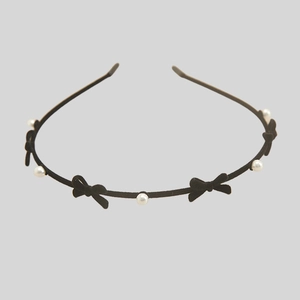 Detail of black flocked headband featuring five bows and six white imitation pearls decor
