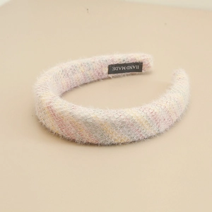 Gros plan détaillé du serre-tête fait main à rayures pastel avec texture en peluche douce