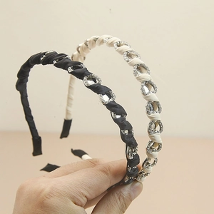 Set di cerchietti con strass neri e beige con elegante design a catena intrecciata