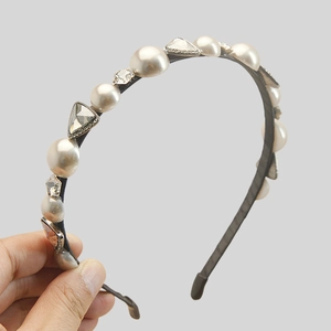 Detail of elegant headband featuring alternating white pearls and clear crystals on black base