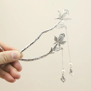 Detailed macro view of silver rose hair pin with cat eye stone and tassel chain