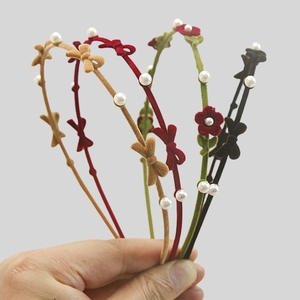 Detail of velvet headbands with floral accents and faux pearls in multiple colors