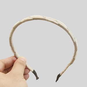 Elegant champagne silk headband with wrapped pearls and comfortable black end tips