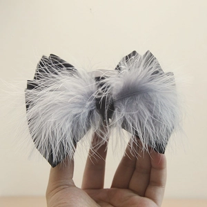 Detail of elegant black satin bow hair claw with grey ostrich feathers for women
