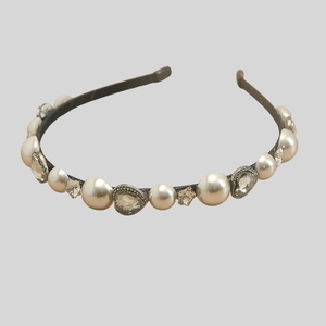 Detail of elegant headband with large white pearls, crystal hearts and stars