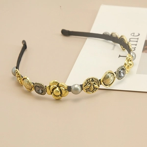 Detail of baroque gold headband with camellia flowers, bee relief and pearls