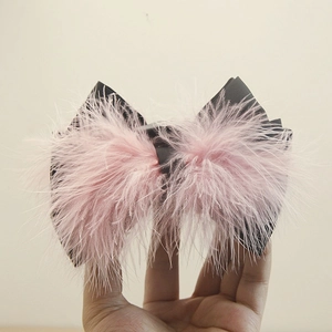 Macro shot of pink ostrich feather bow hair clip with black satin base detail