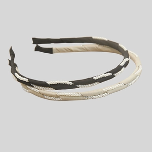 Elegant thin headbands in black and champagne satin fabric with intertwined white pearls