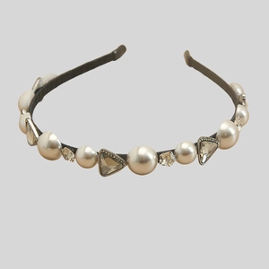 Detail view of vintage pearl headband with sparkling rhinestones on black metal frame