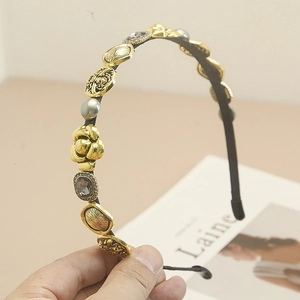 Detailed close-up of Baroque headband featuring gold coins, camellias, and grey pearls