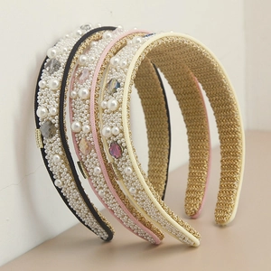 Elegant wide pearl and crystal headband in black, pink, and beige with gold woven details