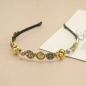 Detailed view of vintage baroque headband with gold camellias and bees on black band