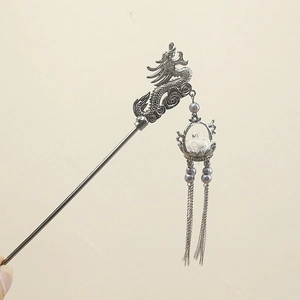 Macro detail of the dragon hair pin featuring gunmetal finish and purple faux pearls