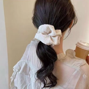 Chouchou blanc élégant avec perles sur tissu plissé stylisé en queue de cheval basse