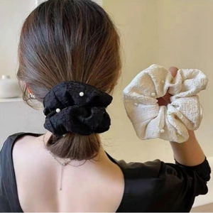 Détail d'un ensemble de chouchous texturés avec perles en noir et blanc crème
