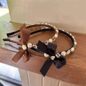 French style hairband set with silk bows, pearls and crystals on dark wood surface