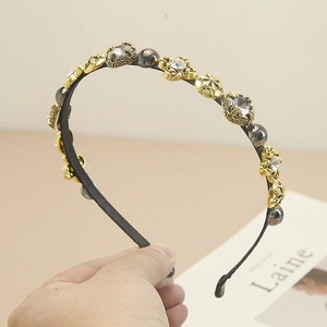 Close-up of golden Baroque headband with inlaid rhinestones and intricate floral carvings