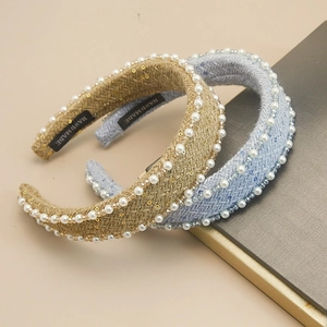 Detail of tweed knit headbands with white pearls and sequins on beige background