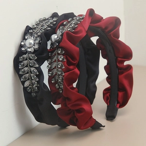 Detail of satin pleated headbands with rhinestone leaf patterns and faux pearls