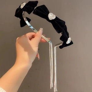 Detail of velvet bow headband with heart-shaped diamonds and dangling rhinestone tassels